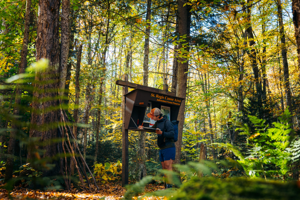 A hiker signing into the register for a mountain
