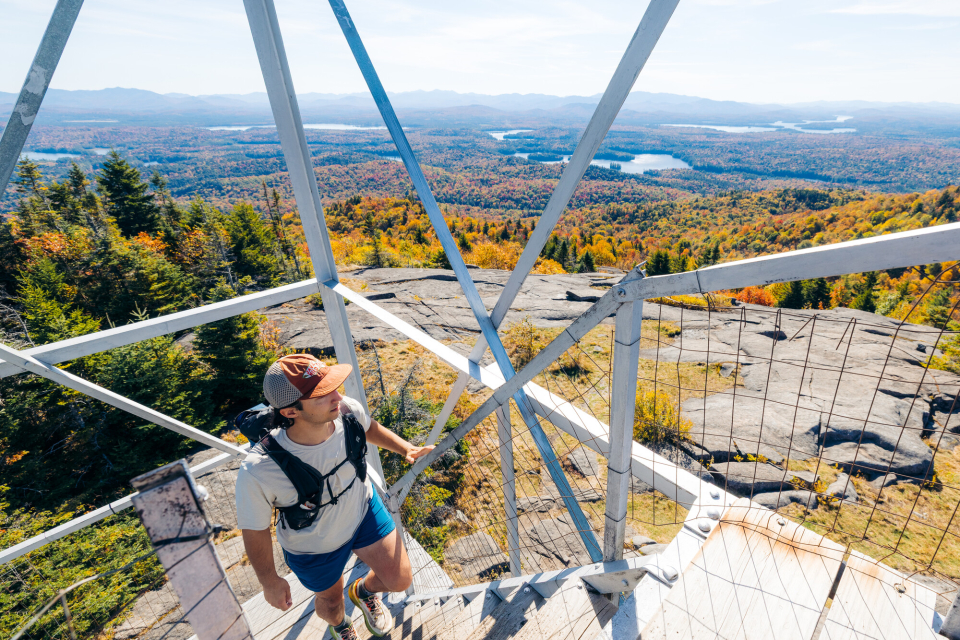 A hiker going up a fire tower in the fall