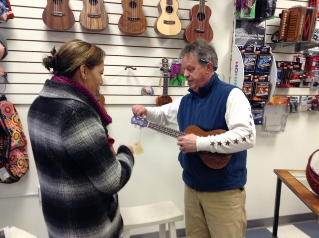 Mark the music man, Ampersound proprietor, demonstrates some ukulele moves for a customer