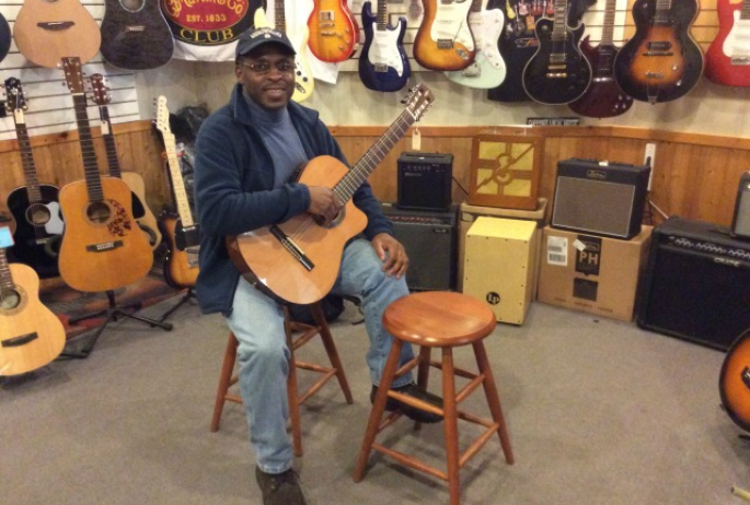 A guitar player tries out a new (or gently used) instrument in Ampersound's guitar room.