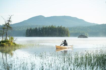 A paddler on a misty mountain lake