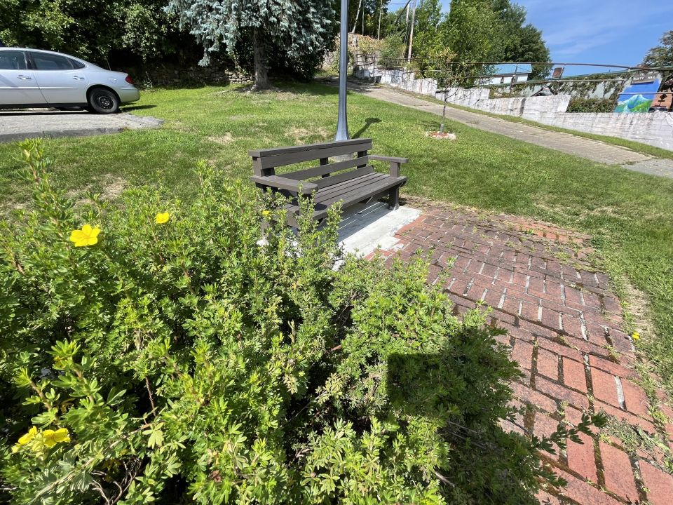 A small park with a bench in the middle of town