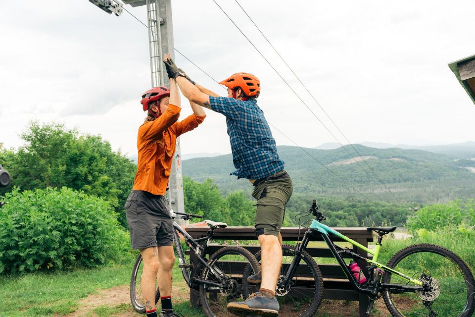 Two mountain bikers high five