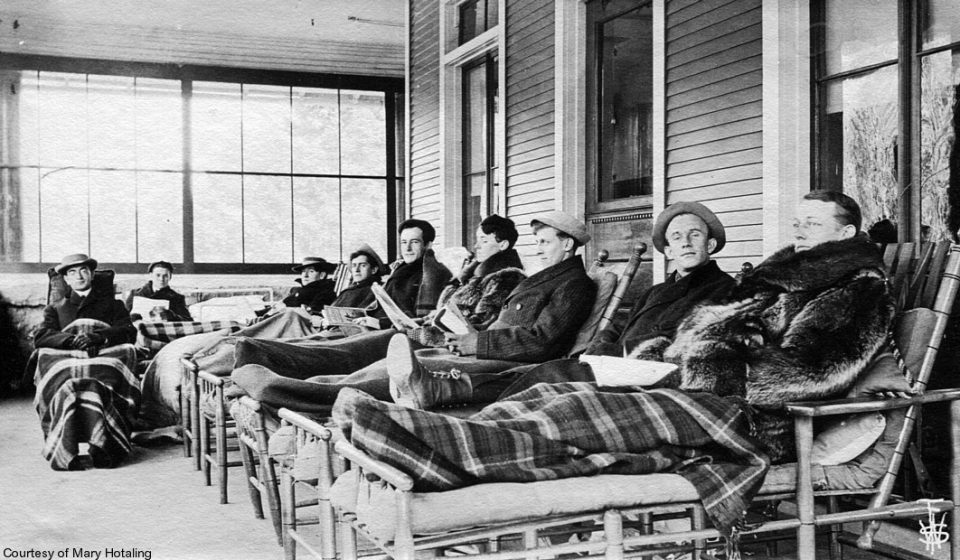 Vintage black and white photo of men on cure chairs at a Saranac Lake sanatorium.