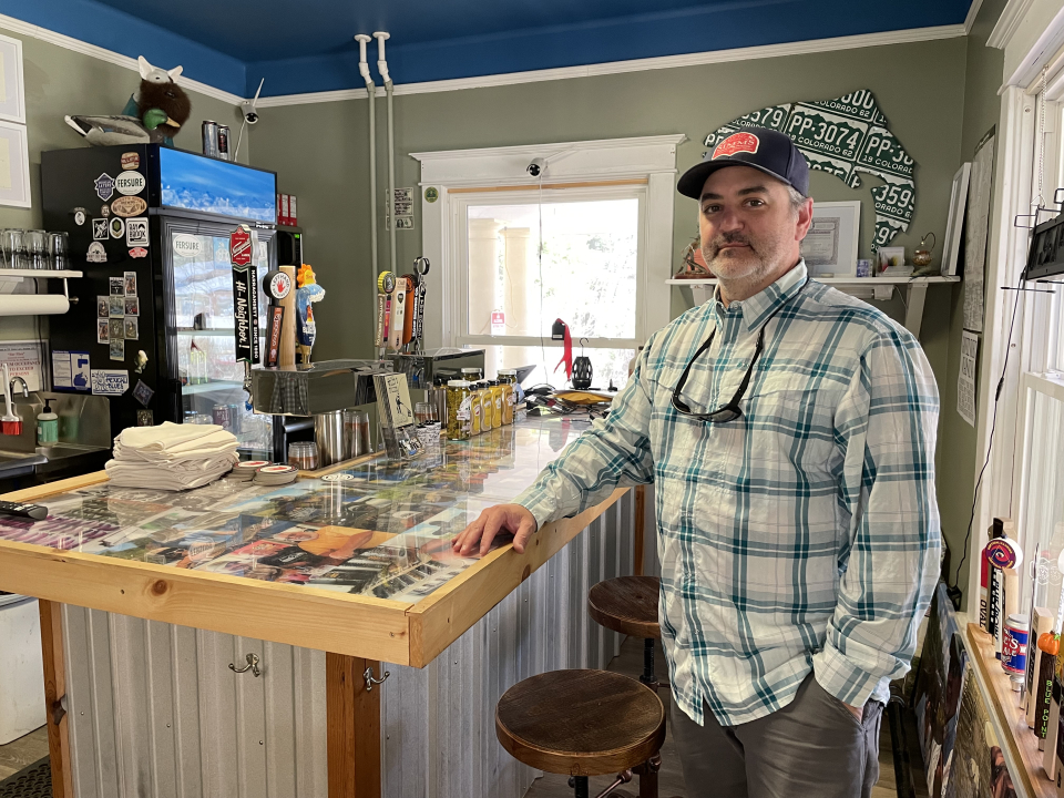 A man stands at a handcrafted bar.