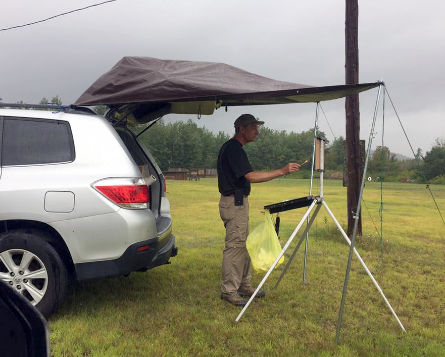 John Slivjak painting in the rain at Adirondack Plein Air Festival 2017. (Photo courtesy of Saranac Lake Artworks)