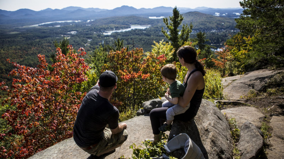 A family sitting at the summit of Baker Mountain.