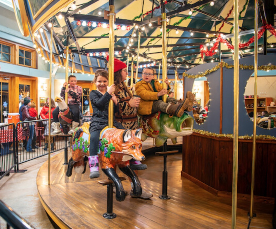 A child rides an adirondack themed carousel.