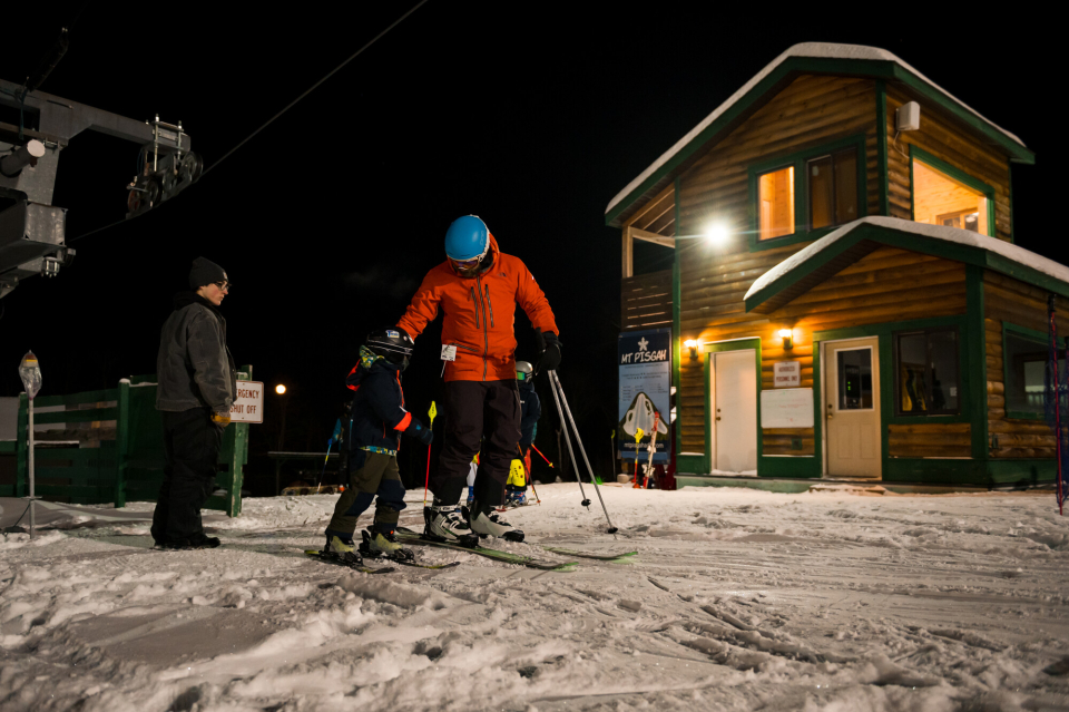 A family night skiing at a local ski hill