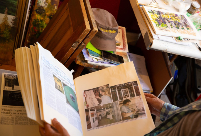 Tim looks at his collection of ArtWalk news articles.