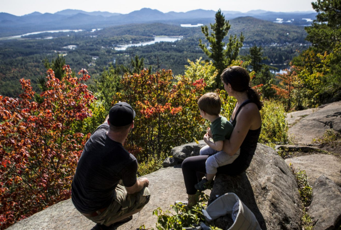 A family sitting at the summit of Baker Mountain.