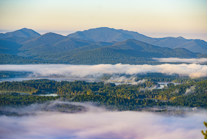 Sunrise at the summit of Baker Mountain with foggy mountain views.