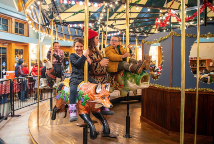 A child rides an adirondack themed carousel.