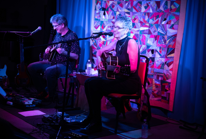 Two guitarists performing live music in Saranac Lake.