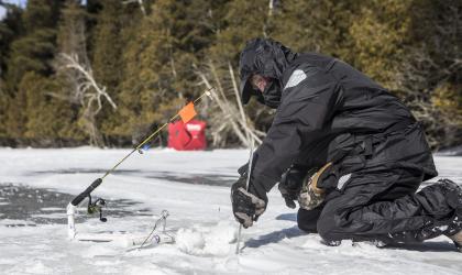 Someone cutting a hold in the ice for fishing