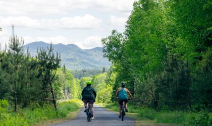 Two people cycle on a rail trail
