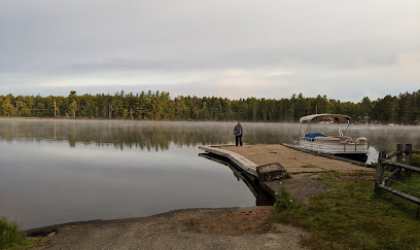 Sturdy boat launch onto a picturesque lake as smooth as glass and ringed with pines