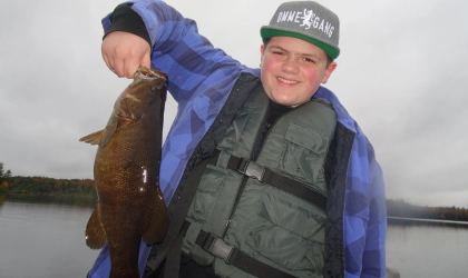 Happy young man holding a fish