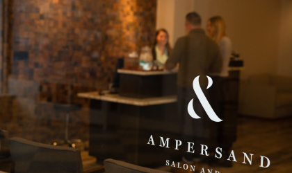 Glass doors separate the hotel from the spa with the copper accent wall and front counter space.