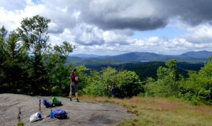 A hiker stands on partially open summit