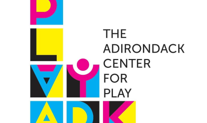 Logo for Play ADK with colorful blocks stacked to spell their name