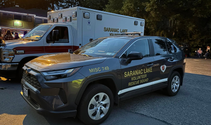 A car and ambulance labeled Saranac Lake Volunteer Rescue Squad.